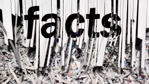 A piece of paper being shredded with the word "facts"